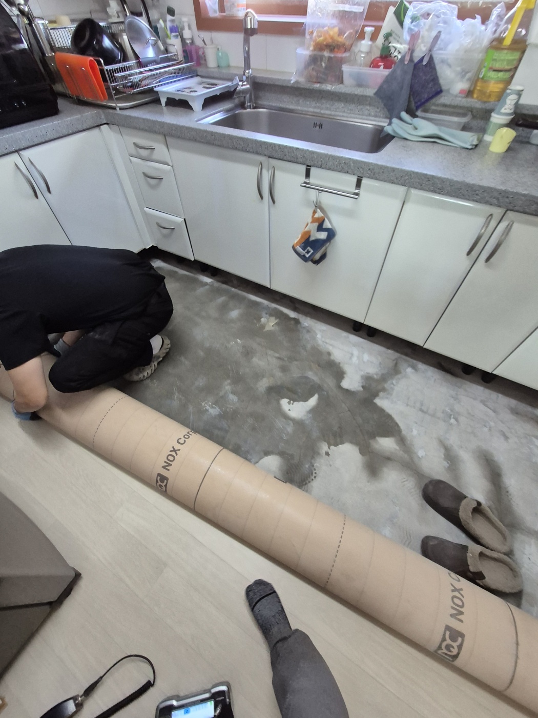 싱크대 앞 바닥재를 걷어 확인하는 모습